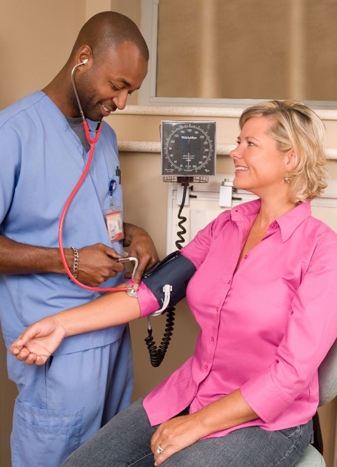 Image 3:  An image showing a male doctor taking the blood pressure of a female patient. This illustrates the monitoring of certain cardiac symptoms.